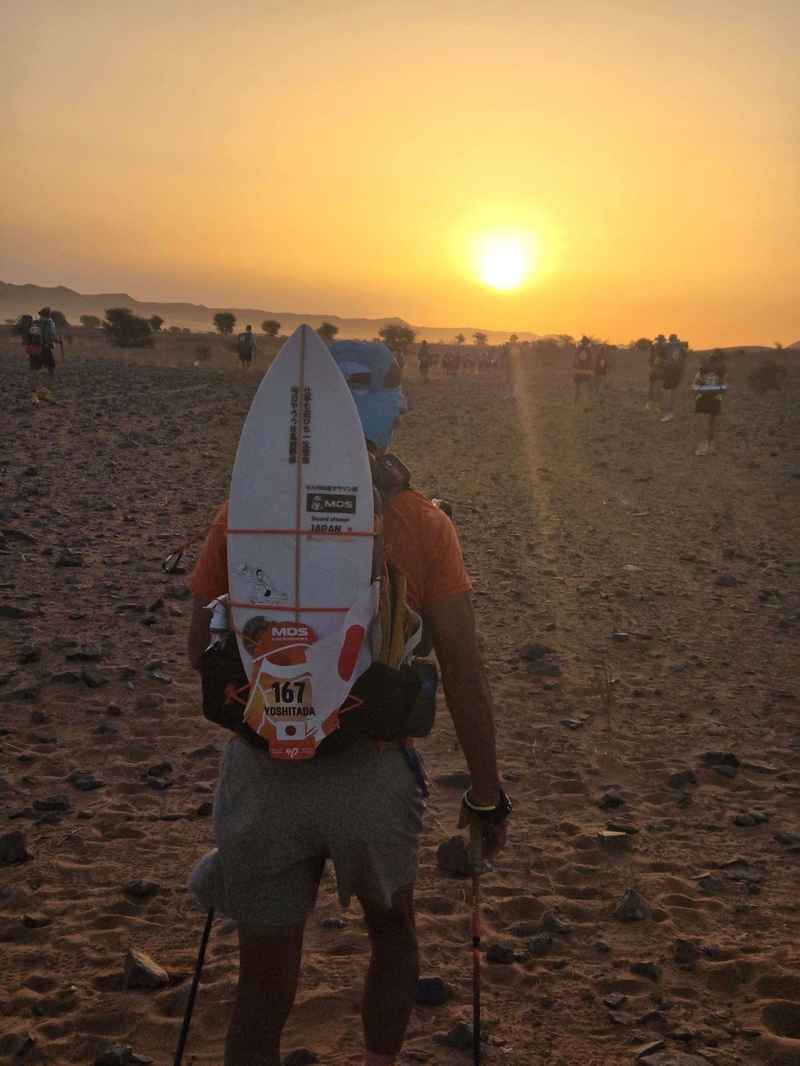 日の出に向かって進むランナー