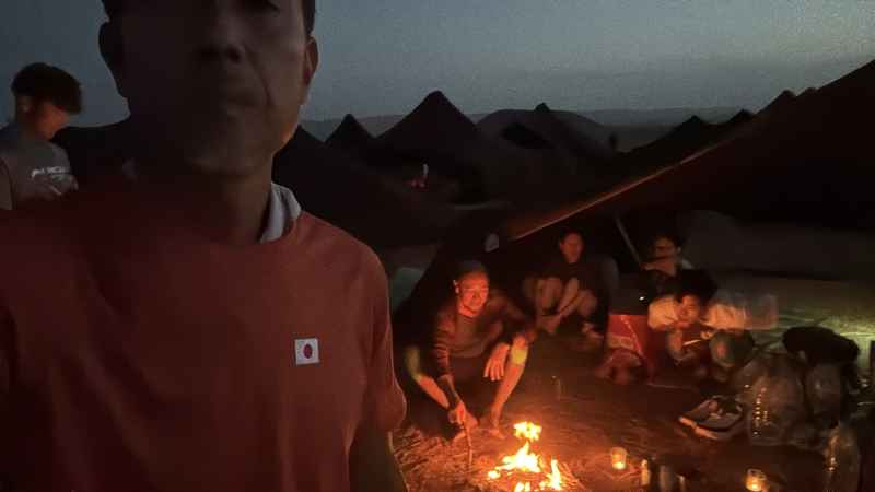 砂漠の夜、焚き火を囲む仲間たち